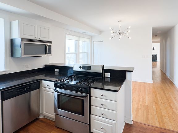 Kitchen with black granite counters and stainless steel appliances