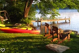 Kayaks, canoe and rowboat.
Firepit and wooden swing on left.
This photo only shows 1/2 of front lawn.