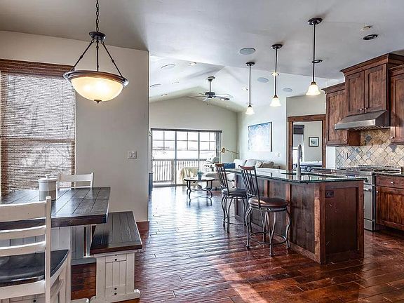 Open kitchen, living and dining. Dining room table, bar stools, couch, side chair and table are included.