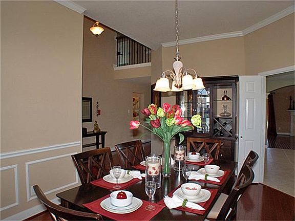 Another view of dining room with entrance to the left and kitchen to the right.  See a glimpse of upgraded wrought iron stair rails.