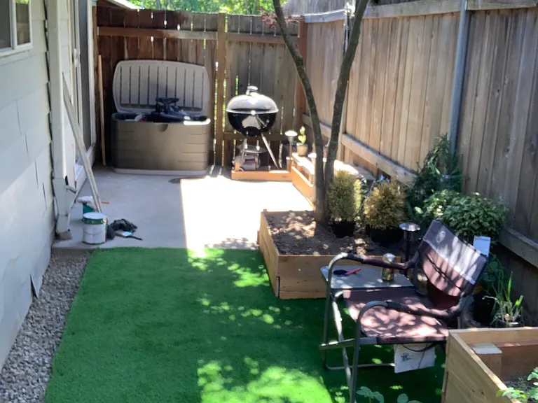 Small fenced in backyard with turf, concrete patio