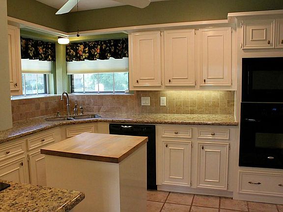 Granite counter tops and tile back splash. Beautiful brushed nickel faucet. Kitchen with butcher blo