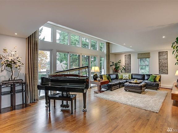 Grand Living Room / Great Room with Gleaming Hardwood Flooring, Silk Drapes, Floor to Ceiling Windows and Fireplace.