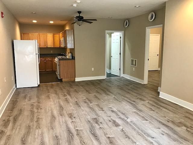 Main entrance view standing in living room. kitchen on left, bathroom in middle and bedroom on the right