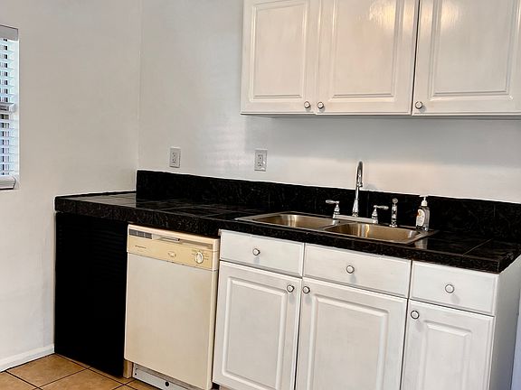 Kitchen sink, dishwasher and cabinetry.