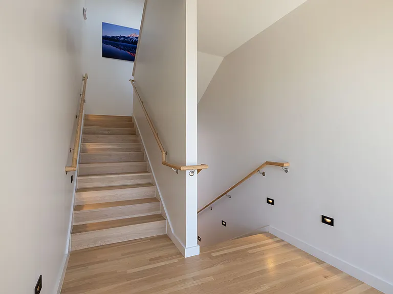 Staircase to the upper floors with artwork on the landing.