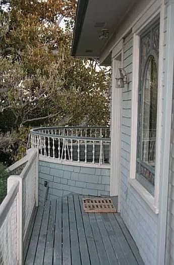 Private stairs lead to entry porch. Circular balcony beyond.