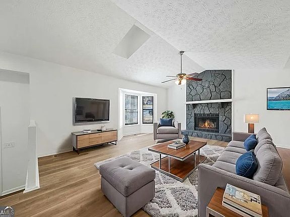 Spacious and open family room with dramatic fireplace and vaulted ceiling.