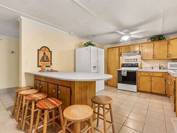 Stove has since been upgraded with a black flat top stove/oven, as well as a stainless steel fridge/freezer.