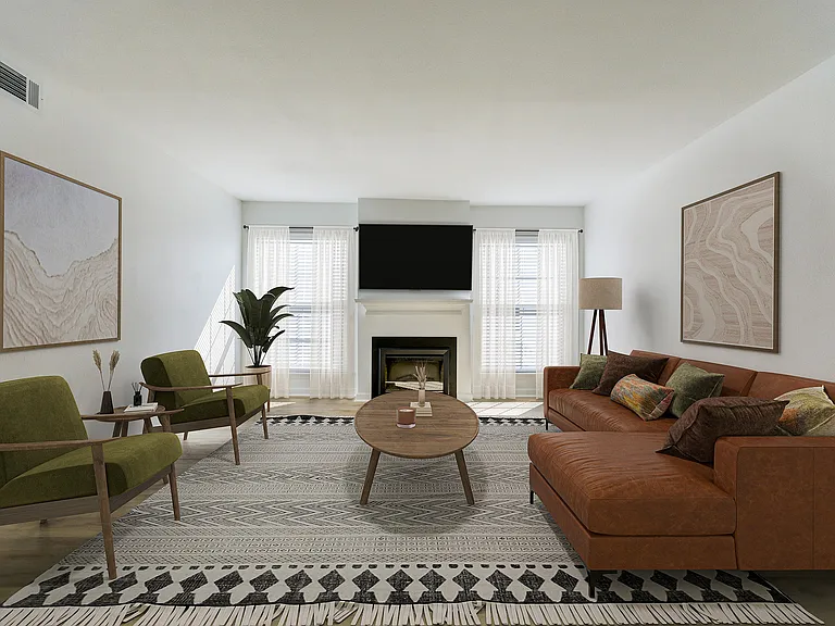 A renovated living room is shown at ReNew on Cantrell with a cozy fireplace and modern furniture.