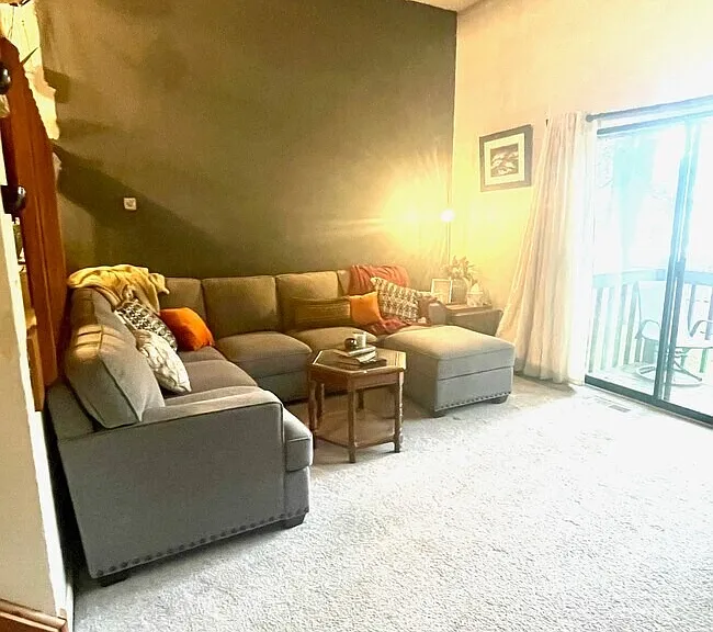Sunken living room with fireplace and sliding glass doors leading to a private deck.
