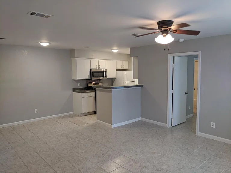 View from the front enrty door. Open living/dining areas. Master suite via door to right.