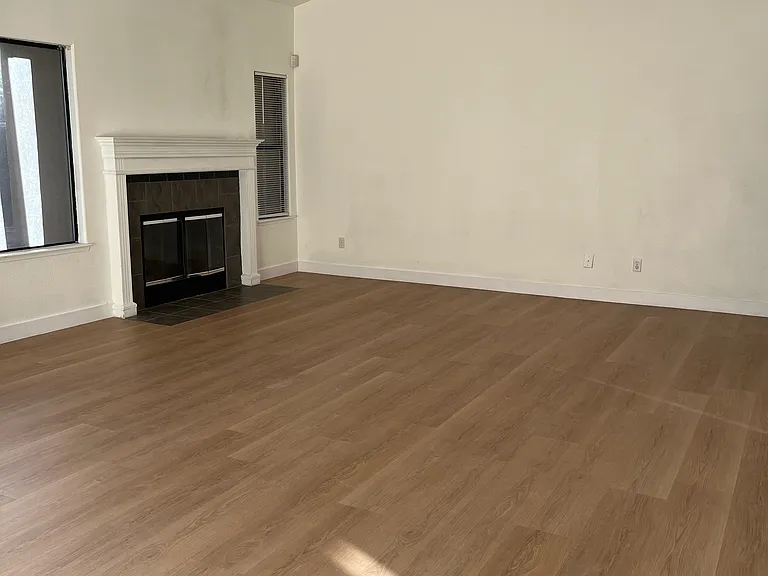 Living room with vaulted ceilings and wood burning fireplace.