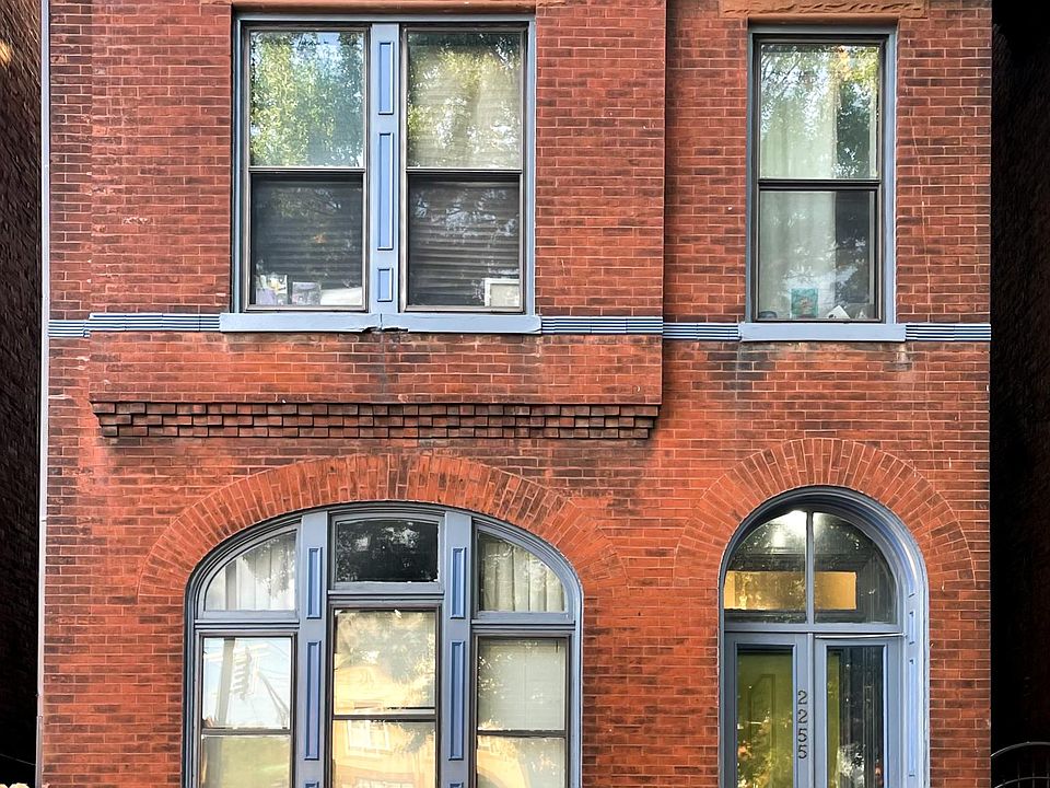 Front of the apartment building with secure common area entry and on-street parking.