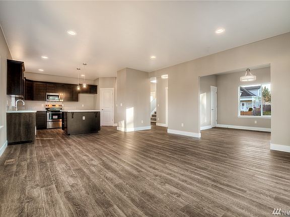 Large open floorplan is what is to LOVE about this home- luxury laminate flooring throughout all of downstairs. From this view you can see the dining room just off the living space. 
