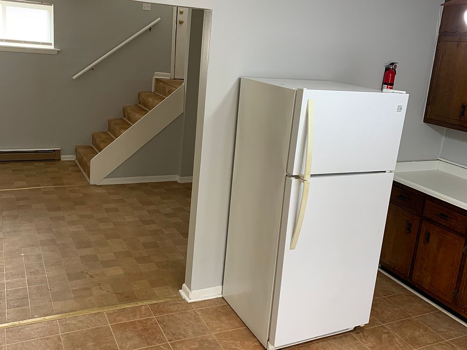 view from kitchen past living room to entry/exit stairs