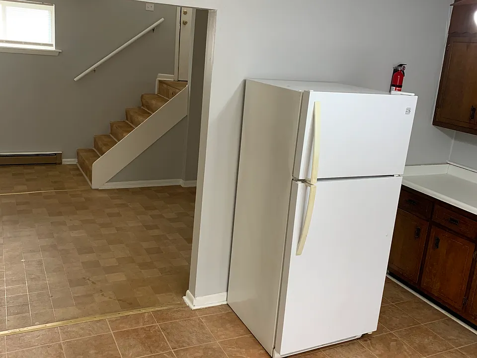 view from kitchen past living room to entry/exit stairs