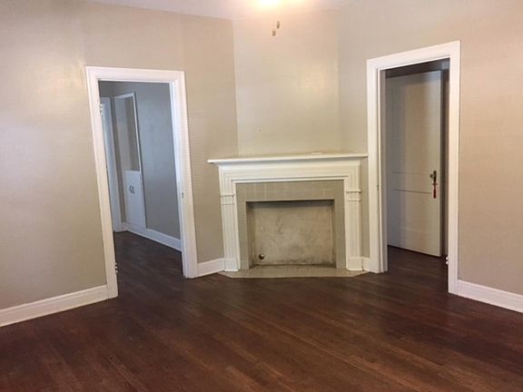 Living room has fake fireplace and lots of windows
