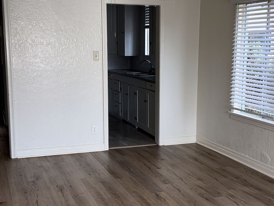 Great Room with view to kitchen and hallway leading to service porch, bedroom, and bathroom - each unit varies slightly