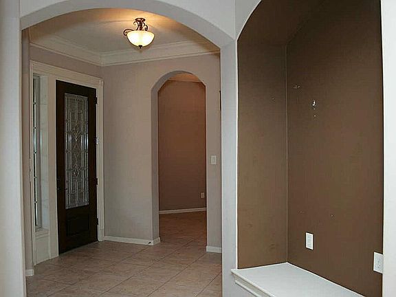 View from the foyer facing the front door. The curved door frames, art niches, and professional faux finishes add to the elegance of this home.