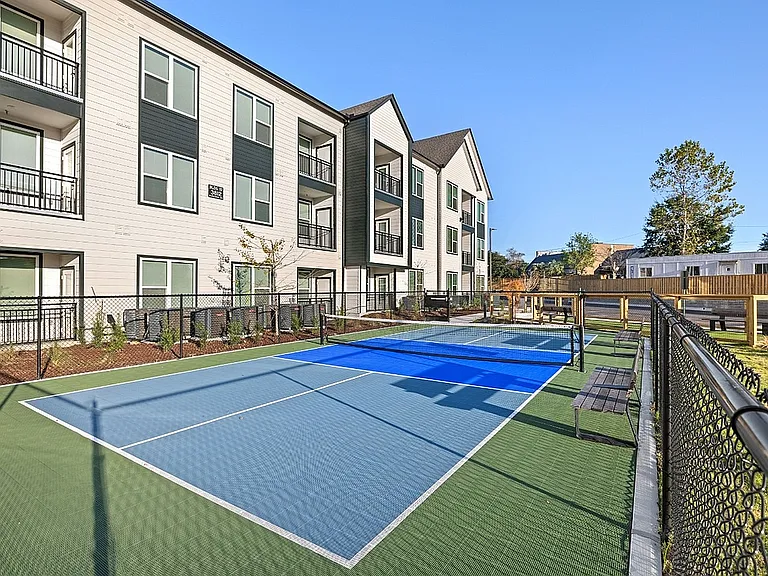 Apartment community pickleball court with outdoor recreation space and resort-style wellness amenities.