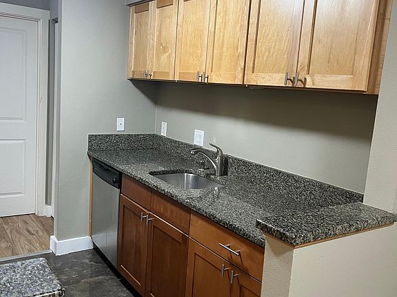 Kitchen has granite tiles on the floor and granite countertops