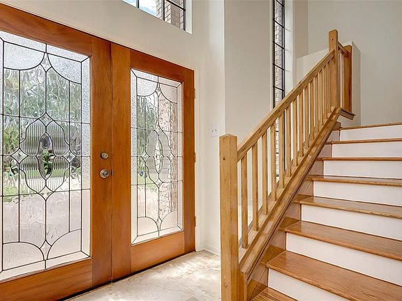 At the entry you are greeted by two double wide lead glass doors and the stairs are real wood.