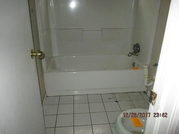 Bathroom clean but missing sink, mirror and light fixture.