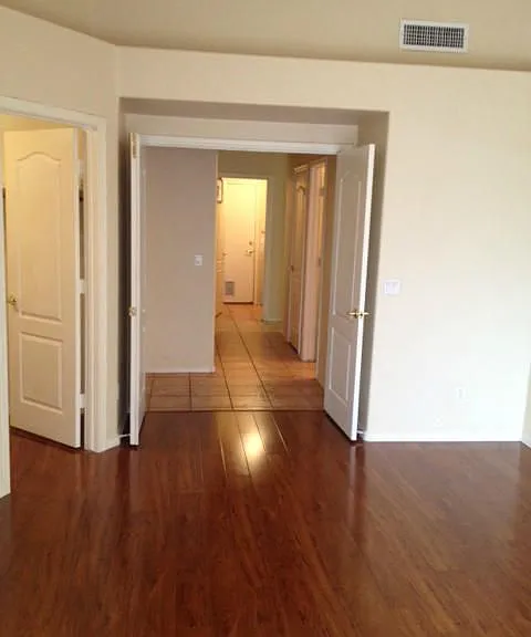 Master bedroom view from sliding doors. Walk-in closet to left and master bedroom entrance to hallway.