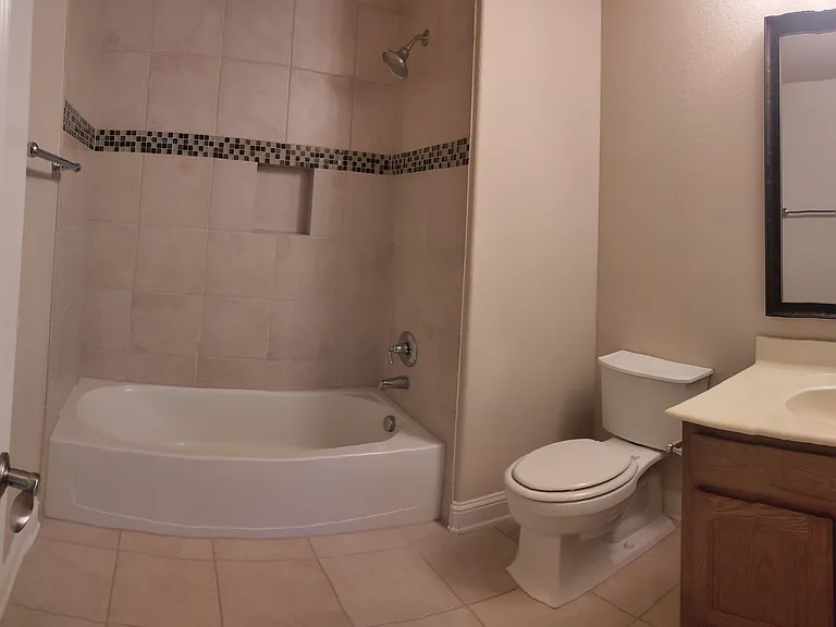 Your private, attached bathroom features a handheld shower over tub, and sink with cabinet. Extra wall shelves or racks may be added to make the space work perfectly for you!