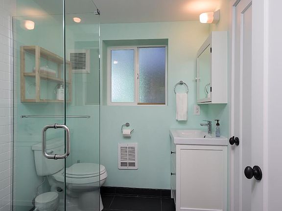 Large walk-in shower, vanity with additional closet storage.