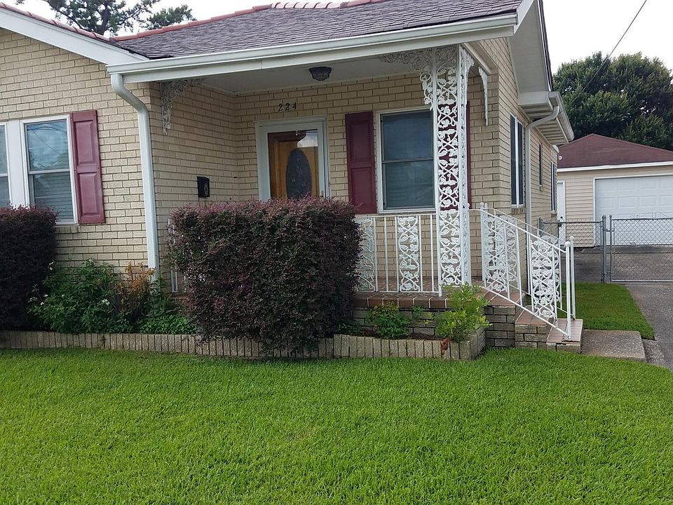 Front of house with long driveway for several cars. Garage w