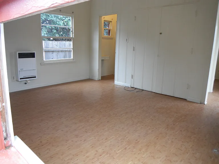 Living room shot through window. Bathroom is through door across room