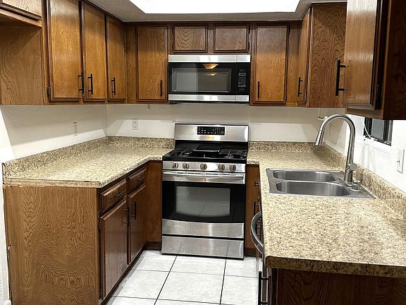 Kitchen with microwave over range and dishwasher to right of sink.
