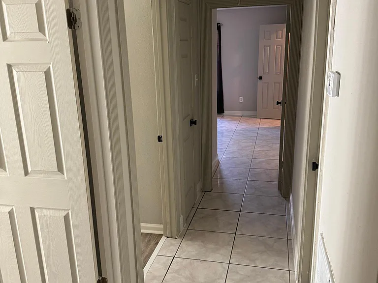 Hallway to secondary bedrooms, guest bathroom, and primary suite.