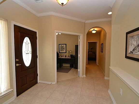 Entry offers a beveled glass front door, tile floors and crown molding.