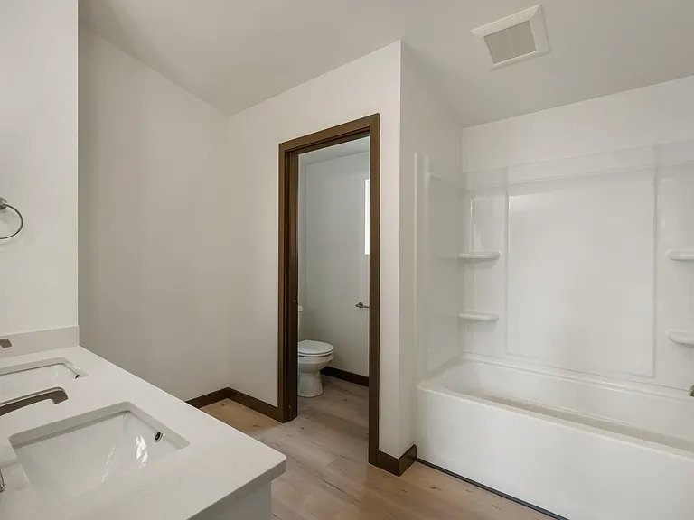 Huge full bathroom with dual sinks and separate room for toilet