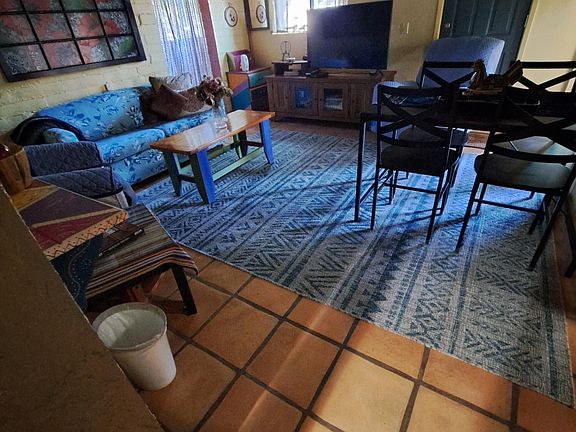 Combined den and dining area by the kitchen and French door entry under the covered smoking porch. Flooring is traditional Saltillo tile.