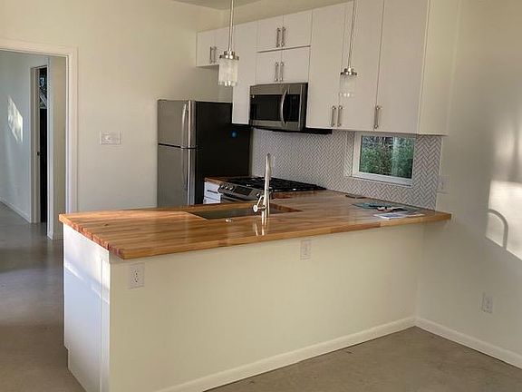 Kitchen counter with room for 3 barstools and electrical outlets for computers or appliances.