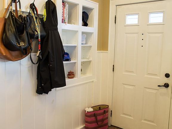 The Entrance is private and the Foyer showcases custom built-in shelves, hooks and a built-in bench.