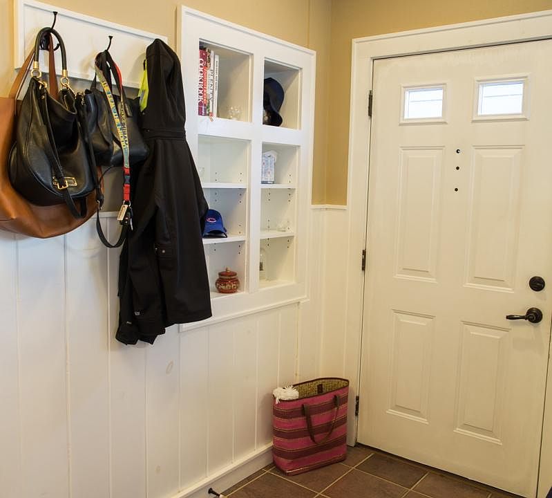 The Entrance is private and the Foyer showcases custom built-in shelves, hooks and a built-in bench.
