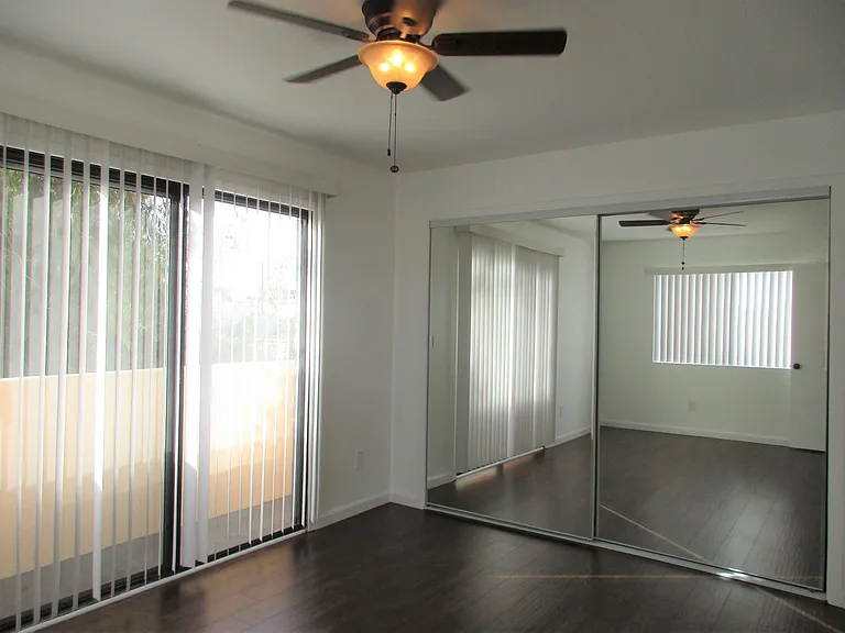PRIMARY BEDROOM WITH SPACIOUS CLOSET, AND SLIDER THAT OPENS ONTO BALCONY.