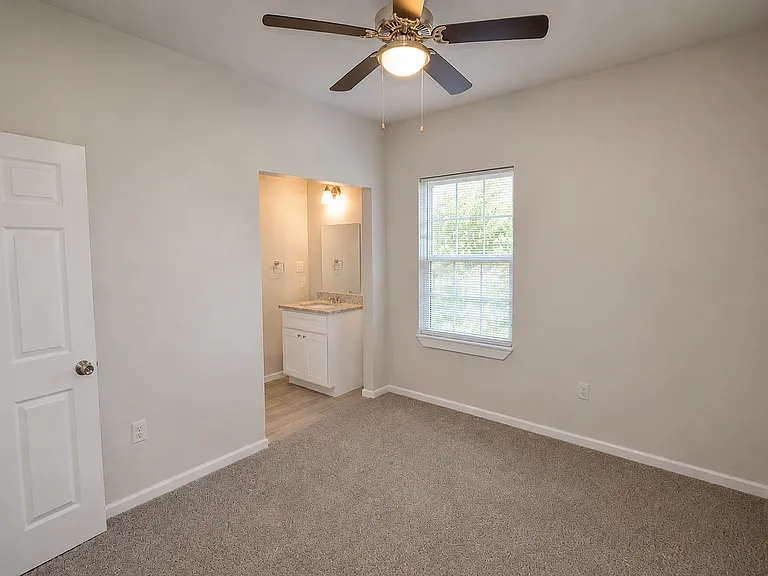 Bedroom 2 with adjacent bathroom and shower unseen in background. The 3rd bedroom is similar in size.