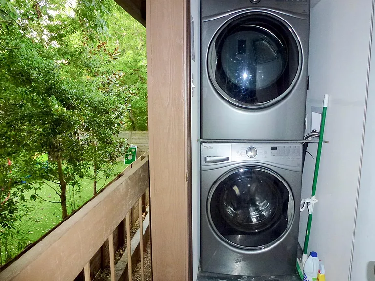 Full size washer and dryer in closet on balcony.