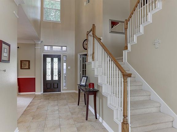 The view toward the front door from the open kitchen and living also show this inviting space.