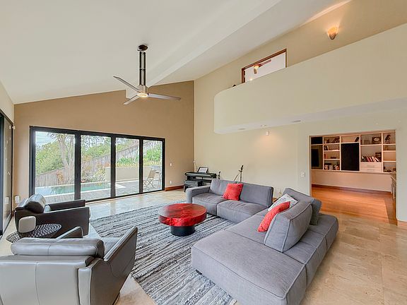 Vaulted ceilings with newly installed accordion doors leading to the pool and patio