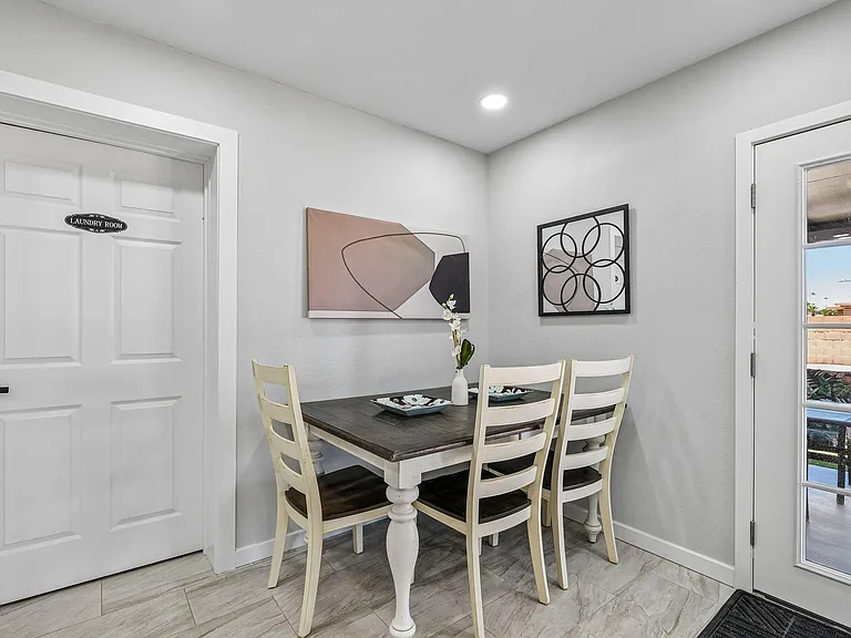 Eat-in dining nook with a four-seat table, wall art accents, and easy access to the patio through a glass door.