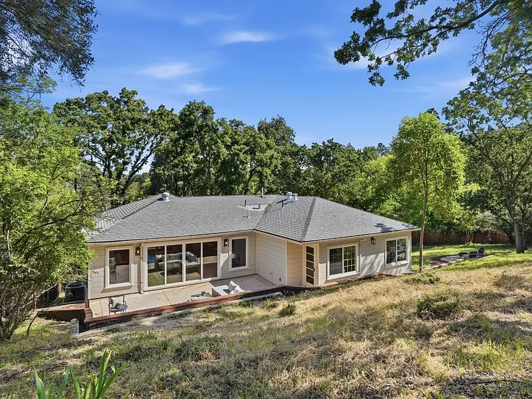 Private backyard surrounded by mature trees and open space