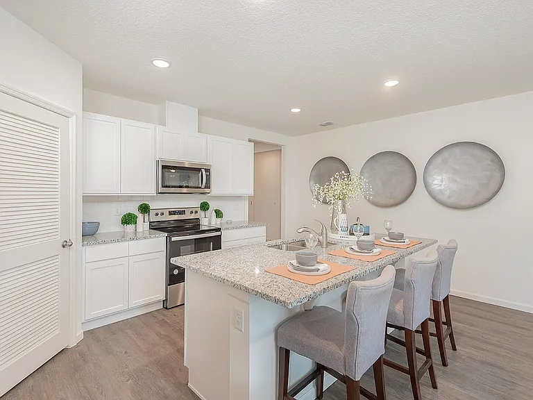 Chic modern kitchen with granite countertops, elegant bar seating, and sleek stainless steel appliances.