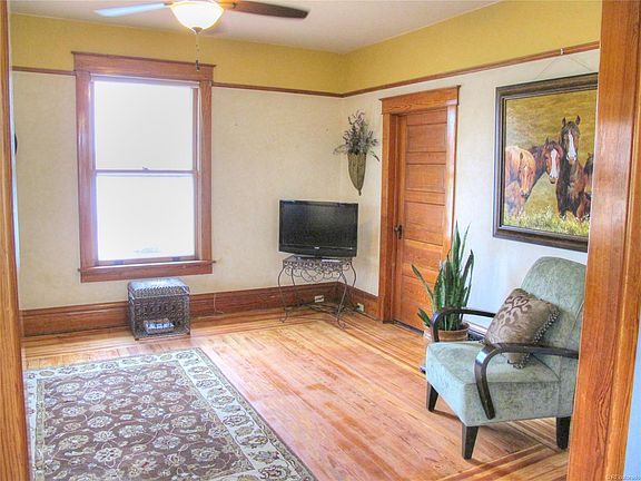 Double door entry into formal living room with original picture framed hardwood